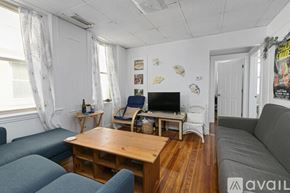 Cambridge apartment for rent - A living room with a grey couch, a wooden table, and a television.