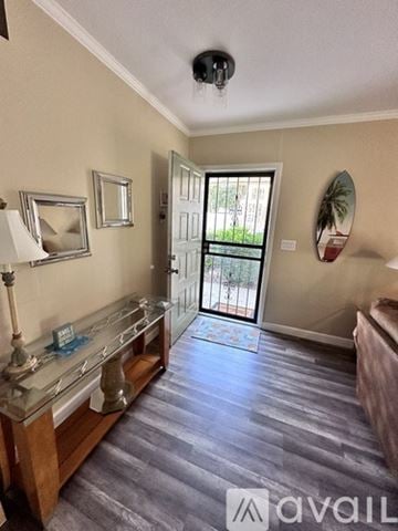 Bradenton condo for rent - A room with a wooden floor and a glass display cabinet.