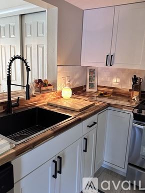 Bradenton condo for rent - A kitchen with white cabinets and a black sink.