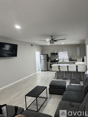 Blythe apartment for rent - A living room with a black and white color scheme and a kitchen in the background.