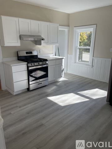 Brockton apartment for rent - A kitchen with white cabinets and a black stove top oven.