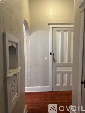 Oswego apartment for rent - A white door with a black handle is in a room with wooden floors.