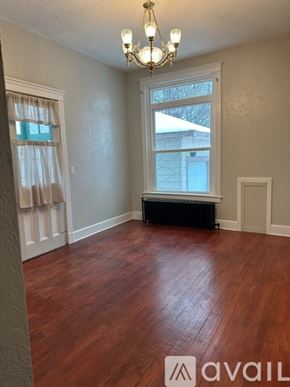 Oswego apartment for rent - A room with wooden floors and a chandelier.