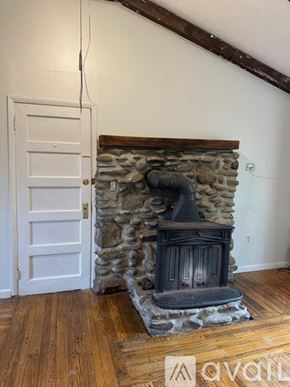 Oswego apartment for rent - A white door is next to a stone fireplace.