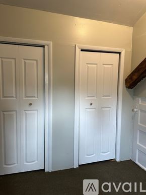 Oswego apartment for rent - Two white doors in a room with a logo on the bottom right.