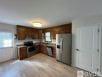 State College house for rent - A kitchen with wooden cabinets and stainless steel appliances.