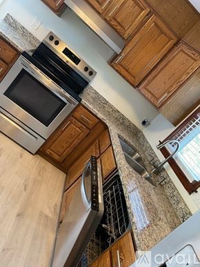 State College house for rent - A kitchen with wooden cabinets and a stainless steel dishwasher.