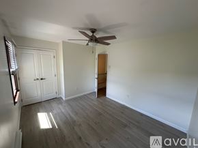 State College house for rent - A room with a ceiling fan and wooden flooring.