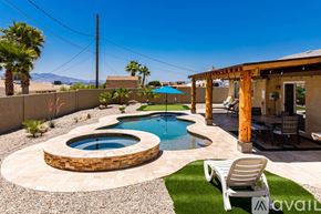 Lake Havasu City house for rent - A wooden pole stands next to a pool with a stone border.