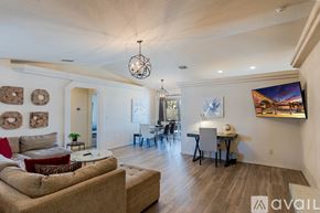 Lake Havasu City house for rent - A bedroom with a bed, a table, a television and two pictures on the wall.