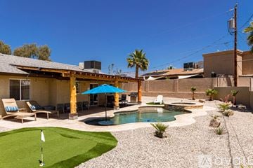 Lake Havasu City house for rent - A living room with a couch, a chair, a coffee table, and a television mounted on the wall.