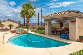 Lake Havasu City house for rent - A pool with a slide and a house with a patio.