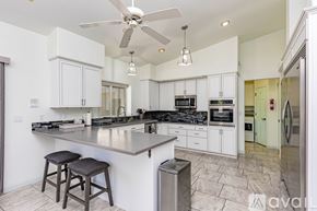 Lake Havasu City house for rent - A modern kitchen with white cabinets and a large island.