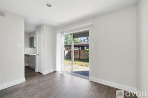 Houston apartment for rent - A spacious room with a view of a wooden fence and greenery outside.