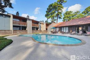 Houston apartment for rent - A swimming pool in a backyard surrounded by a patio and a house.