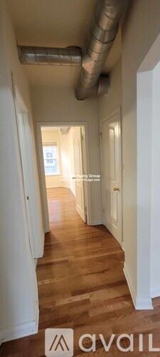 Chicago apartment for rent - A hallway with wooden floors and white walls.