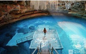 Lecanto townhouse for rent - A person is standing in a blue pool with a wooden walkway leading to it.