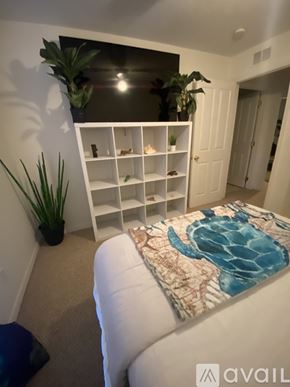 Lecanto townhouse for rent - A bedroom with a bed and a shelf with plants on it.