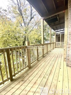 Chicago apartment for rent - A wooden deck with a railing and trees in the background.