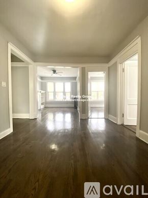 Chicago apartment for rent - A spacious room with wood flooring and a ceiling fan.