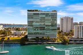 North Bay Village apartment for rent - A modern building with a green roof is situated by the water.
