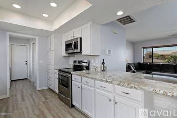 Lake Havasu City house for rent - A kitchen with white cabinets and a granite countertop.