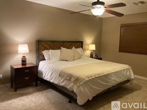 Lake Havasu City house for rent - A bedroom with a bed, two lamps, and a ceiling fan.