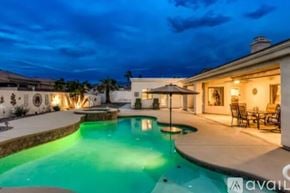 Lake Havasu City house for rent - A pool with a lit up edge and a house in the background.