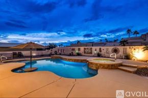 Lake Havasu City house for rent - A pool with a waterfall and a water slide.