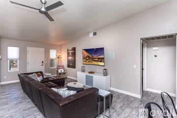 Lake Havasu City house for rent - A living room with a brown couch and a ceiling fan.