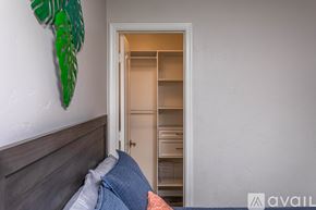 Lake Havasu City house for rent - A bedroom with a bed and a green leaf decoration on the wall.