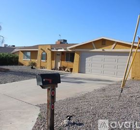 Lake Havasu City house for rent - A yellow house with a black mailbox in front.