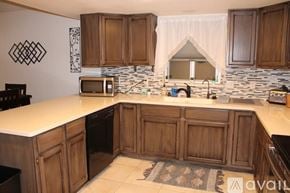 Lake Havasu City house for rent - A kitchen with wooden cabinets and a white countertop.
