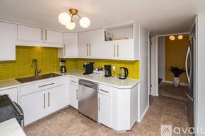 Lake Havasu City house for rent - A kitchen with white cabinets and a green backsplash.
