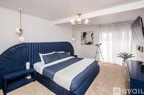 Lake Havasu City house for rent - A bedroom with a large bed and a blue headboard.