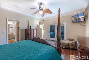 Lake Havasu City house for rent - A bedroom with a large bed and a ceiling fan.