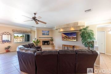 Lake Havasu City house for rent - A living room with a brown leather couch and a painting on the wall.