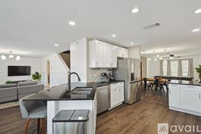 Saginaw house for rent - A modern kitchen with white cabinets and stainless steel appliances.
