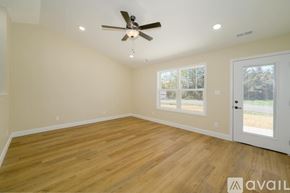 Knoxville townhouse for rent - A room with a ceiling fan and wooden flooring.