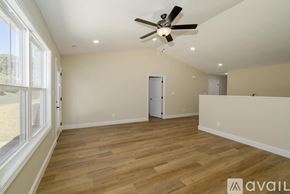 Knoxville townhouse for rent - A spacious room with a ceiling fan and wooden flooring.