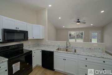 Knoxville townhouse for rent - A kitchen with white cabinets and a black stove top oven.