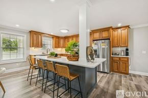 Lascassas house for rent - A modern kitchen with wooden cabinets and a dining table set for four.