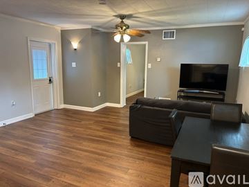 Pinellas Park apartment for rent - A living room with a black leather couch and a television.