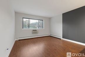 Chicago apartment for rent - A room with wooden flooring and a window with a view of buildings outside.