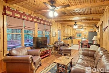 Lakemont house for rent - A living room with brown leather furniture and a ceiling fan.