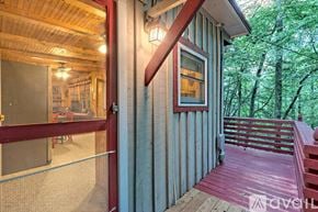 Lakemont house for rent - A wooden deck with a red railing and a glass door leading to a dining area.