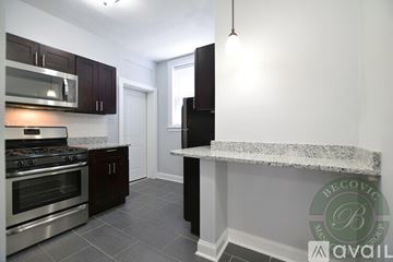 Chicago apartment for rent - A kitchen with dark wood cabinets and a stainless steel oven.