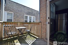 Chicago apartment for rent - A patio with a table and chairs is shown with a building in the background.