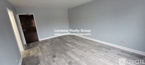 Chicago apartment for rent - A room with a wooden floor and a door on the left side.