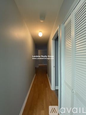 Chicago apartment for rent - A hallway with a wooden floor and white walls.